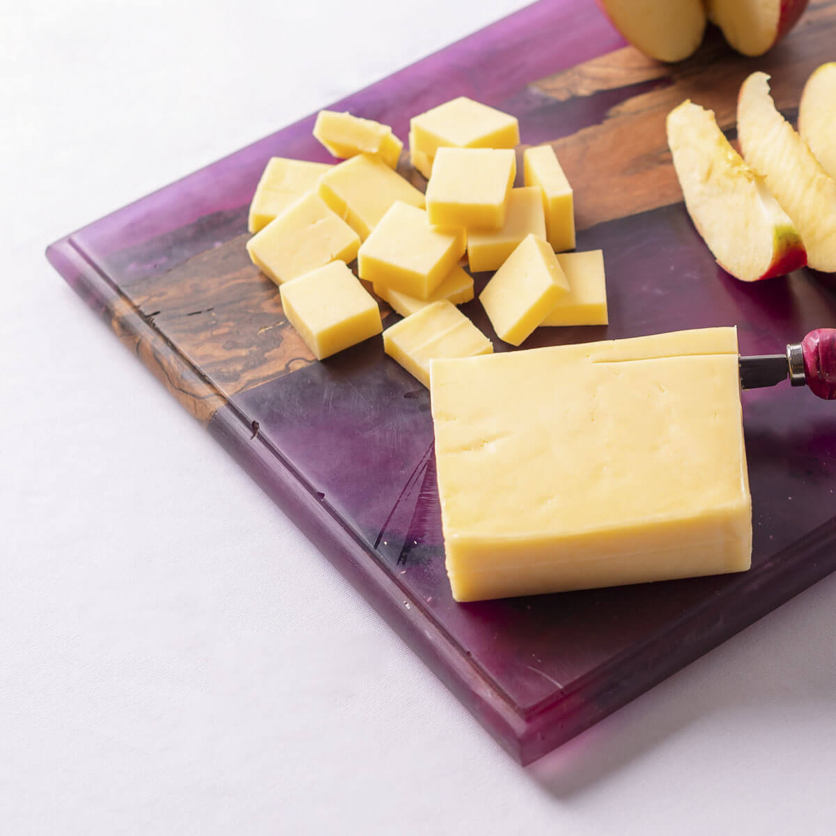 Cheese and apples on a purple resin charcuterie board